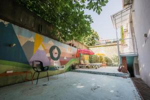 ベオグラードにあるHostel Bongoの椅子が2脚置かれた壁と壁画が描かれた壁