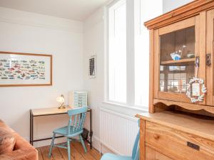 a living room with a blue chair and a desk at The Old Toll House in Teignmouth