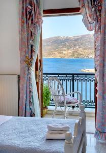 a bedroom with a view of the ocean from a balcony at Infinity view in Sitia