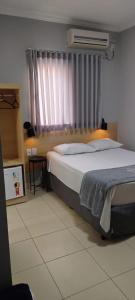 a bedroom with a large bed and a window at Hotel Graal Inn Queluz in Queluz