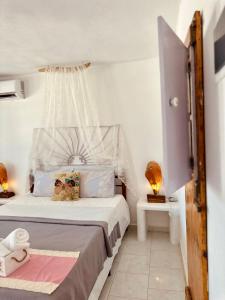 a white bedroom with a bed with a canopy at Errika's Sweet Home in Provatas