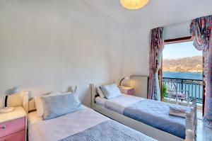 a bedroom with two beds and a window with a view at Infinity view in Sitia