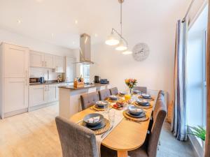 eine Küche und ein Esszimmer mit einem Holztisch und Stühlen in der Unterkunft Whinstone House in Craster