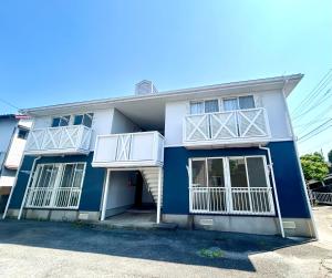 a blue and white building with white balconies at En warikogawa in Kitakyushu