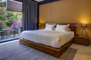 a bedroom with a large bed and a balcony at MX Grand Suites in Mexico City