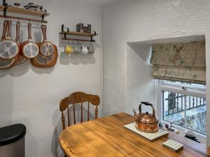 a kitchen with a wooden table with a tea kettle on it at Lyndene Cottage in Moel-tryfan