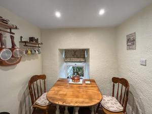 a dining room with a wooden table and chairs at Lyndene Cottage in Moel-tryfan