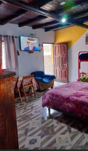 a bedroom with a bed and a flat screen tv at Cabañas virgen de la candelaria in Maimará