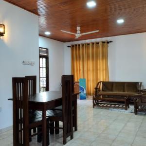 una sala da pranzo con tavolo e pianoforte di Villa Aroma Ahangama ad Ahangama