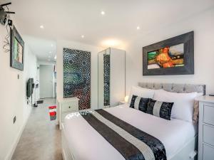 a bedroom with a white bed and a large window at Little Heron - Uk40928 in Holdenhurst +6 photos