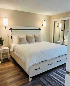 a bedroom with a large white bed and a mirror at Hope's Hideaway in Blakeslee
