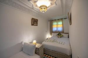 a small bedroom with two beds and a couch at Riad Zara Fez in Fès +3 photos