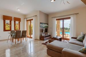 a living room with a couch and a table at Aphrodite Hills Junior Villas Junior Villa J032 Air Conditioning Private Pool 2 Bedrooms P in Paphos