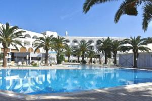 a large swimming pool with palm trees in front of a building at Golf Residence- Families and Couples Only in Hammam Sousse