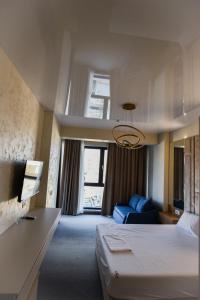 a hotel room with a bed and a blue couch at Beach Vibe Hotel Mamaia Nord in Mamaia Nord +35 photos