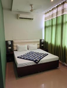 a bedroom with a large bed with a green curtain at Hotel Green Land in Mohali