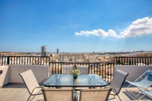 a patio with a table and chairs on a balcony at 3 bedroom penthouse with jacuzzi and roof terrace VFRA1-1 in Sliema