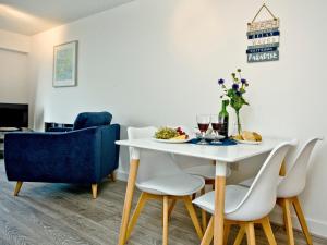 a dining room with a white table and chairs at Fistral Escape in Crantock