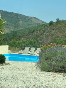 a swimming pool with lounge chairs next to a mountain at Vacation home with pool in Quillan