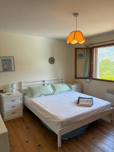 a bedroom with a bed and a window and a lamp at Vacation home with pool in Quillan +18 photos