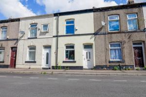 ein Backsteinhaus mit weißen Türen und Fenstern auf einer Straße in der Unterkunft Newly renovated 3 Ensuite bedroom house in bury, 5 people in Bury