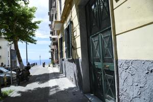 a narrow street with a green door on a building at Cerasella B&B in Naples