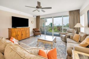 a living room with a couch and a tv at St. Simons Grand #120 in Saint Simons Island