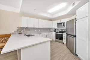 a kitchen with white cabinets and a white counter top at St. Simons Grand #120 in Saint Simons Island