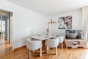 a white dining room with a table and chairs at Appartement Cosy in Paris