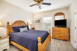 a bedroom with a bed and a flat screen tv at St. Simons Grand #120 in Saint Simons Island +32 photos