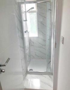 a shower with a glass door in a bathroom at Sunny Gardens 3-Bed Apartment in London in Hendon