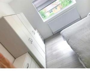 a room with a bed and a window and a floor at Sunny Gardens 3-Bed Apartment in London in Hendon