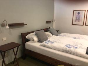 a bedroom with a bed with white sheets and a table at Ferienwohnung Sonnentau 2 in Holzminden