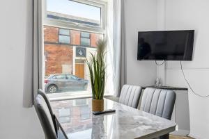 ein Esszimmer mit einem Tisch und einem Fenster in der Unterkunft Newly renovated 3 Ensuite bedroom house in bury, 5 people in Bury