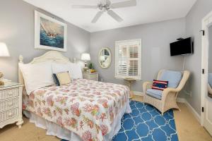 Un dormitorio con una cama y una silla y un televisor. en St. Simons Grand #126, en Saint Simons Island 35 fotos más