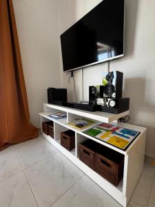 un centro de entretenimiento blanco con TV de pantalla plana en la parte superior en Villa privada con jardín,2 dormitorios, en Playa Blanca