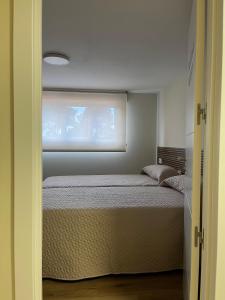a bedroom with a bed and a window at Casa Loaira Hostal in Isla de Arosa