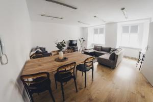 a living room with a wooden table and chairs at COŚ Apartament Żydowska 33 in Poznań
