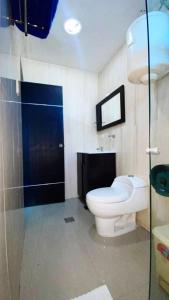 a bathroom with a toilet and a glass shower at Hotel Aventura Suites Tucacas in Tucacas