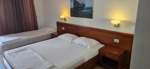 Una habitación de hotel con dos camas y dos lámparas. en Hotel Porto Otrant, en Ulcinj