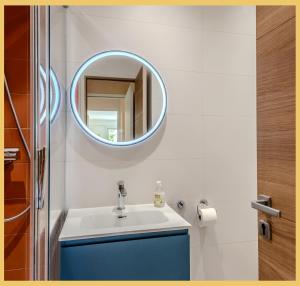 a bathroom with a sink and a mirror on the wall at Chez Aiko I Appartement T3 I Ferney-Voltaire in Ferney-Voltaire