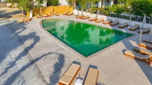 an overhead view of a swimming pool with chaise lounge chairs at Ulin Boutique Hotel in Borsh