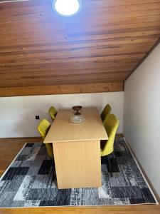 una sala da pranzo con tavolo in legno e sedie gialle di Kamena Ćuprija a Konjic