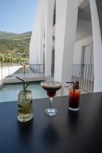 two cocktails sitting on a table on a balcony at Ulin Boutique Hotel in Borsh