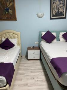 two beds in a room with purple pillows at HOmE SUITE in Istanbul