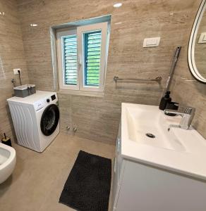 une salle de bains avec lave-linge et lavabo dans l'établissement True Apartment Jure - FREE Boat Trip for 7 or more Nights!, à Biograd na Moru