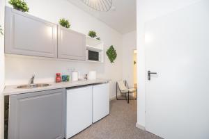 a kitchen with white cabinets and a sink at City Nest Vilnius Oldtown in Vilnius