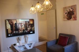 a living room with a flat screen tv on the wall at King-size 3Bed House in Leicester in Leicester
