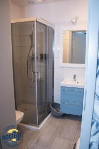 a bathroom with a shower and a toilet and a sink at Azyl in Dębki +26 photos