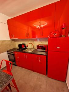 a red kitchen with a sink and red cabinets at Apartments Vesna Luxury & Stefan Ap 10 in Paralia Katerinis +24 photos